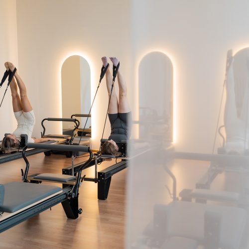 Calm reformer room with mirrors, Peaceful Pilates space with warm lighting and wooden floors